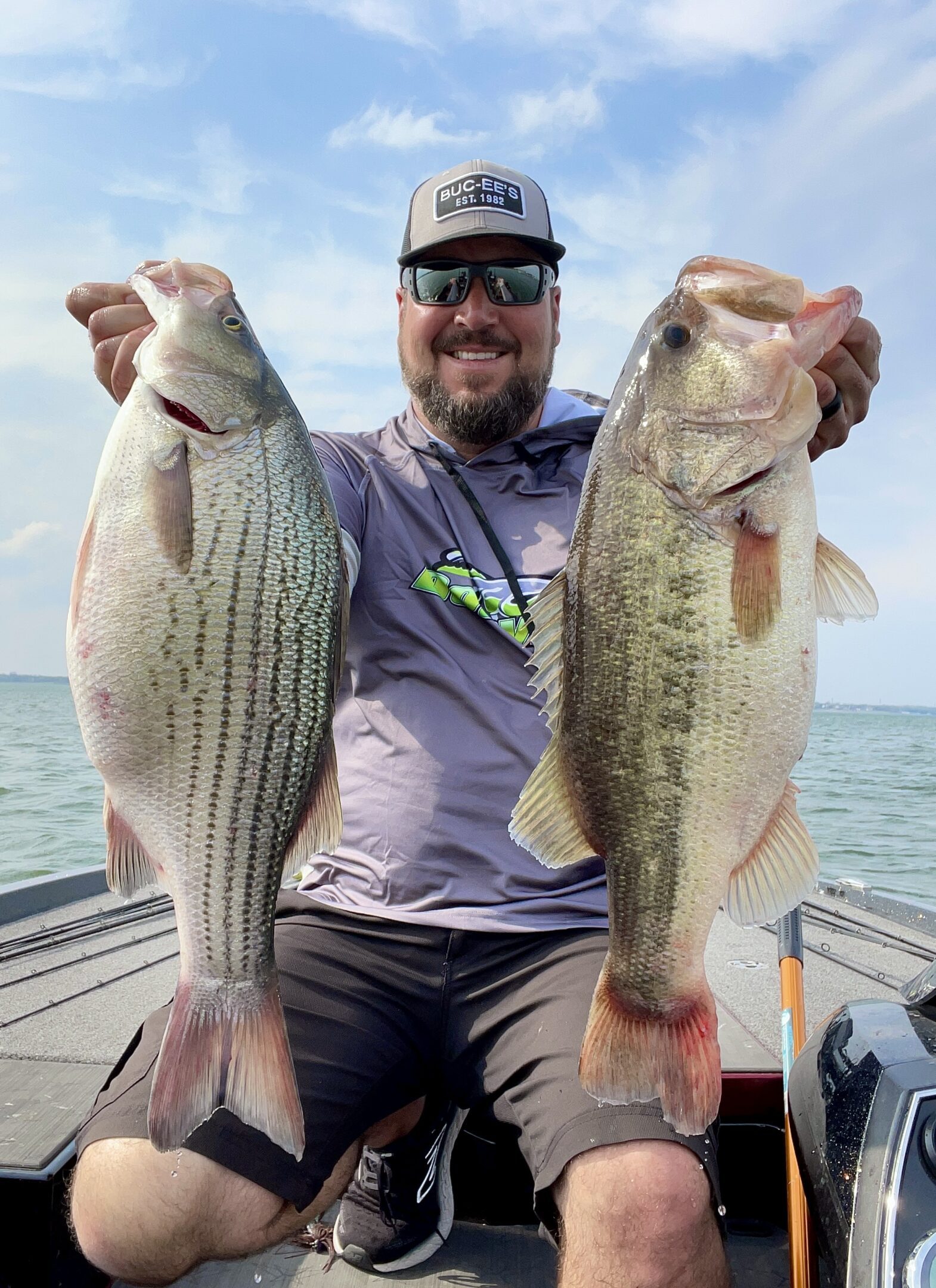 Man holding two large fish on boat