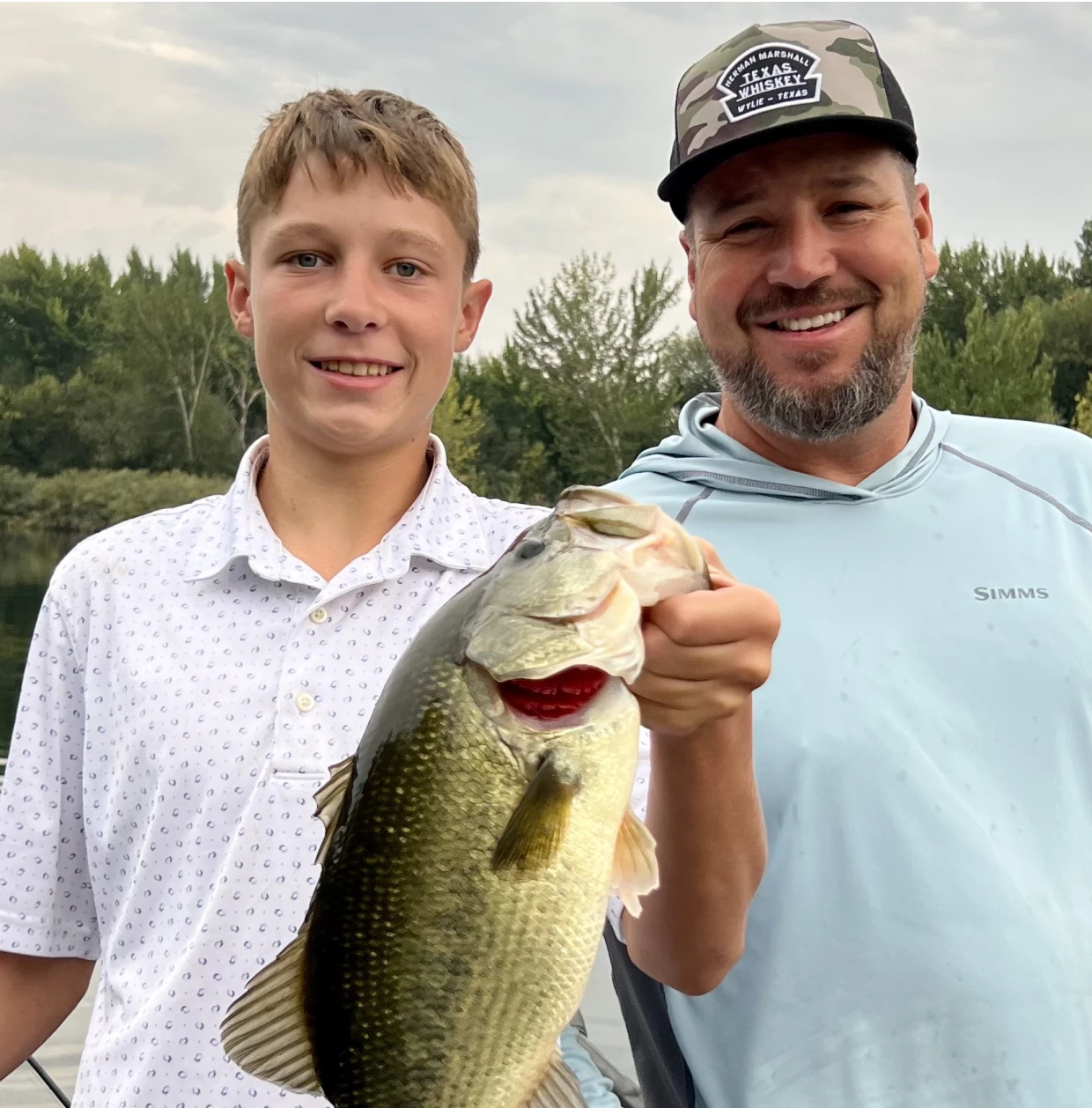 Father and son holding a large fish
